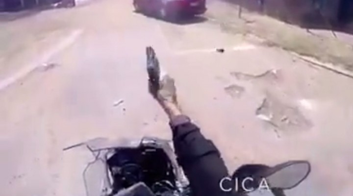 policjant strzela z motocykla podczas jazdy z