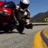 Motocyklista podnosi kamere jadac na kolanie - knee down