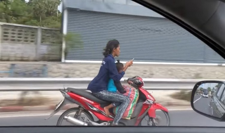 kobieta na skuterze z dzieckiem i smartfon
