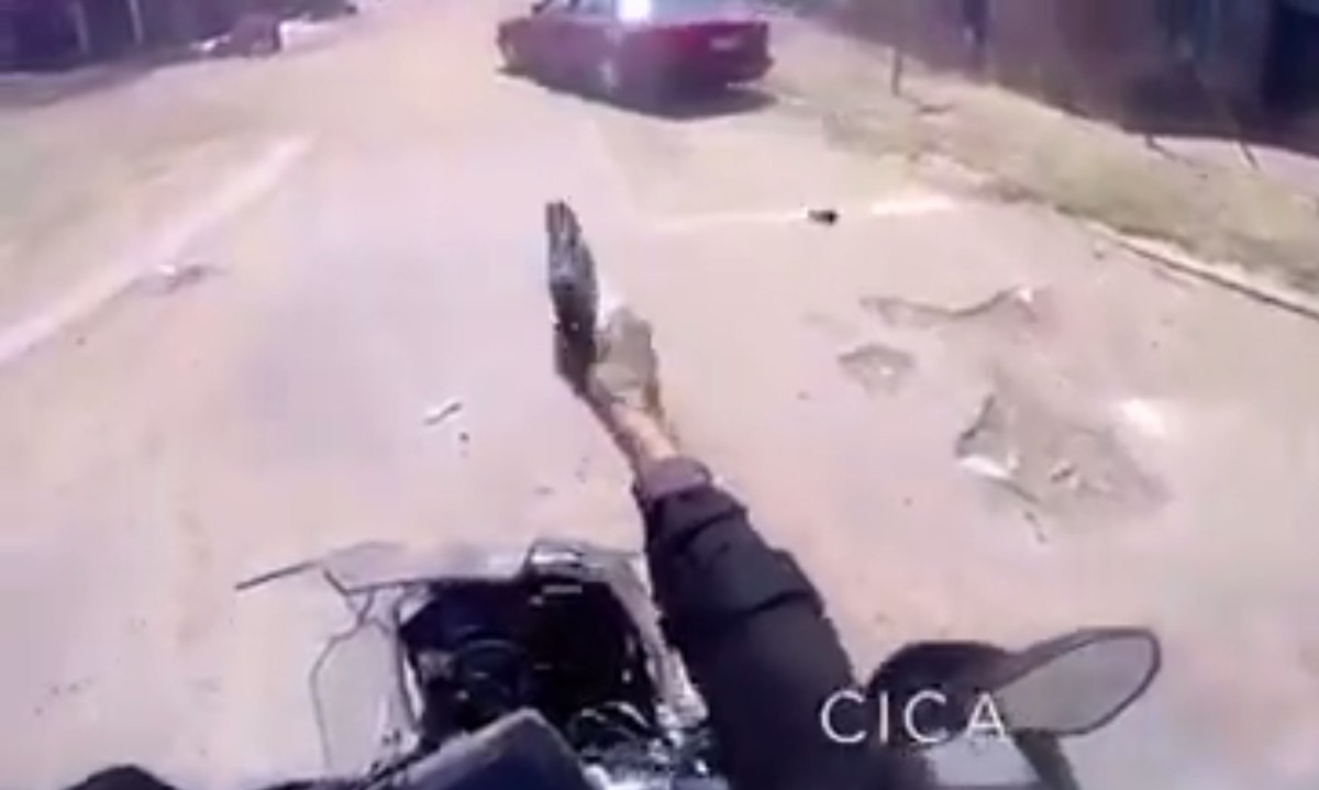 policjant strzela z motocykla podczas jazdy z